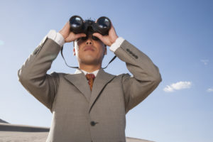Businessman with binoculars looking to future of marketing