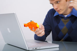 Man pointing gun at laptop because of bad website