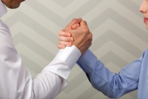 two people shaking hands and trusting each other