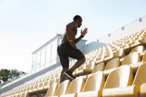 young man runner on a stadium running upstairs like overwhelmed business trying to follow marketing plan