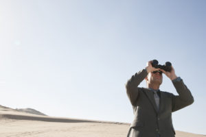 Businessman with binoculars looking into future